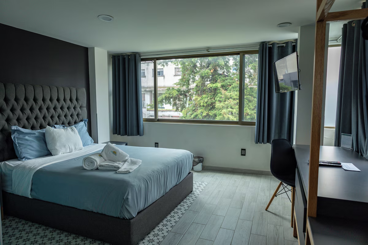Habitación Matrimonial de Casa Romita con cama de lujo y vista a Roma Norte